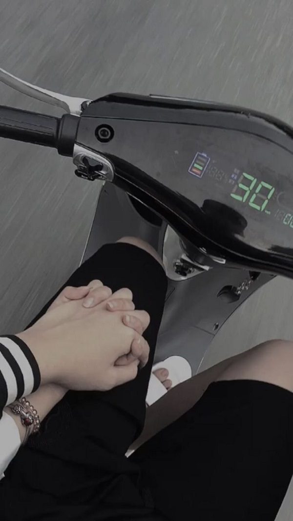 Ảnh đôi tình nhân nắm tay đi dạo bằng xe máy