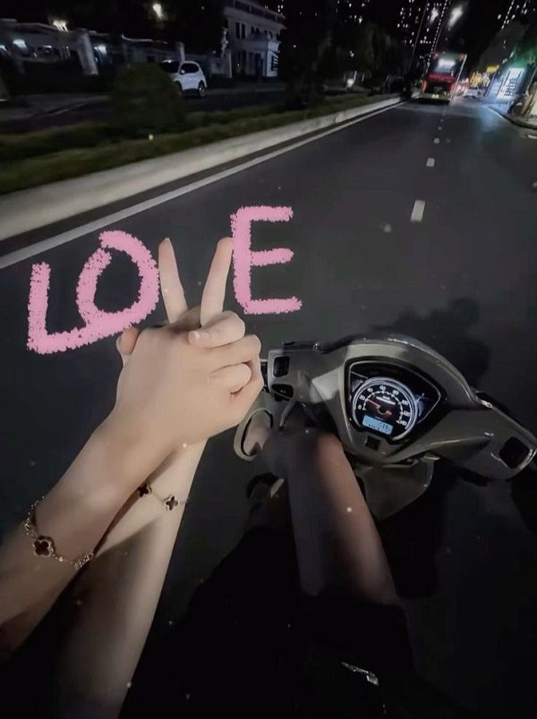 Khoảnh khắc đôi lứa nắm tay nhau khi đi xe máy