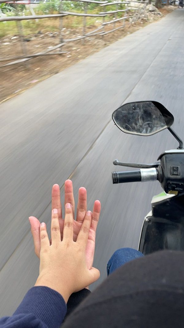 Nắm tay nhau cùng đi xe máy trên đường dài