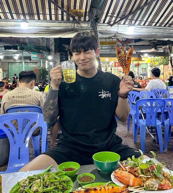 Bàn tay cầm ly bia trong ánh sáng dịu